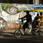 man giving a visual arts tour on a two-seater tricycle